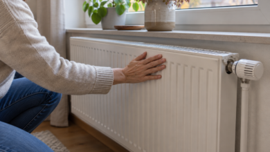 Bewohnerin prüft die Oberfläche eines Heizkörpers am Fenster [Bildinhalt mit KI erstellt]